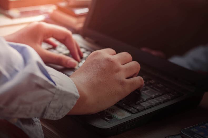 Homem utilizando o software para distribuidora no notebook da empresa
